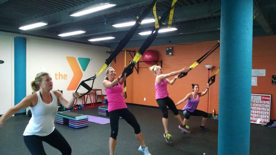 YMCA female members training in group TRX class