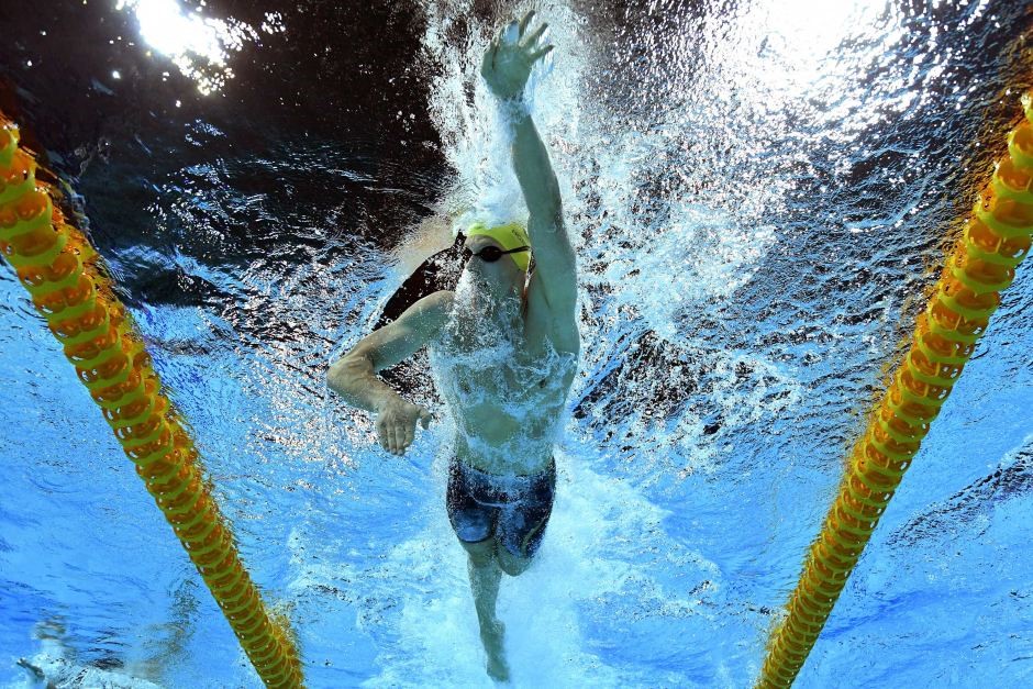 Man swimming in pool between lap lanes