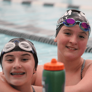 Young female swim team members facing camera