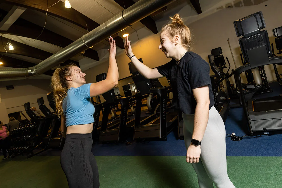 Two teens high five after a youth fitness program