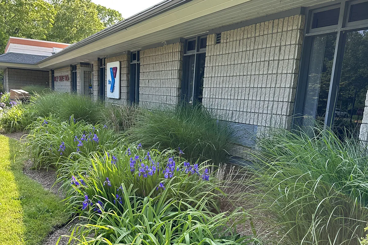 The front exterior wall of a YMCA location, showing the flowerbeds.